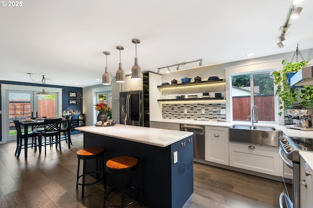 kitchen featuring decorative backsplash, light countertops, appliances with stainless steel finishes, and a sink