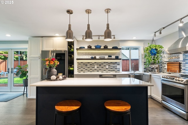 kitchen with backsplash, white cabinets, stainless steel appliances, and light countertops