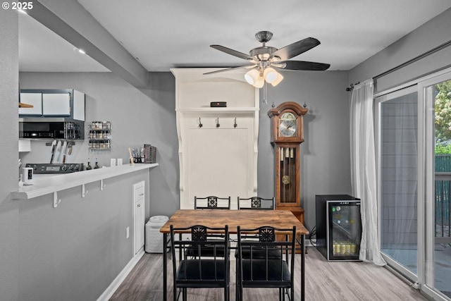 7143 SW Sagert St Unit 104, Tualatin, OR 97062 - dining area with wine cooler, wood finished floors, a ceiling fan, and baseboards