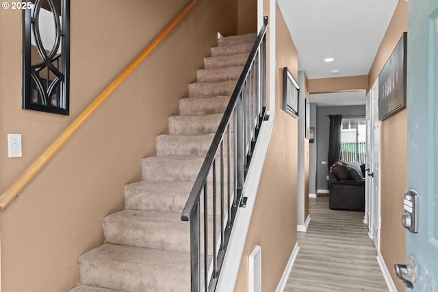 7143 SW Sagert St Unit 104, Tualatin, OR 97062 - stairway featuring baseboards, wood finished floors, and recessed lighting