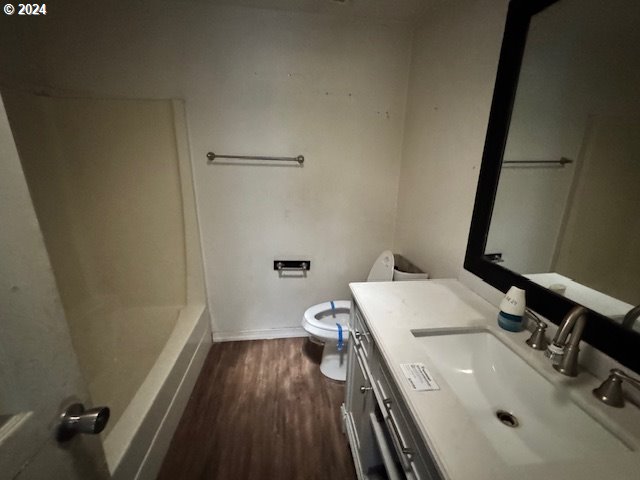 full bathroom featuring vanity, hardwood / wood-style floors, shower with separate bathtub, and toilet