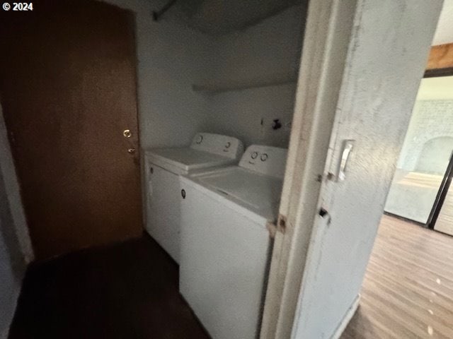 laundry area with washer and dryer and light hardwood / wood-style flooring