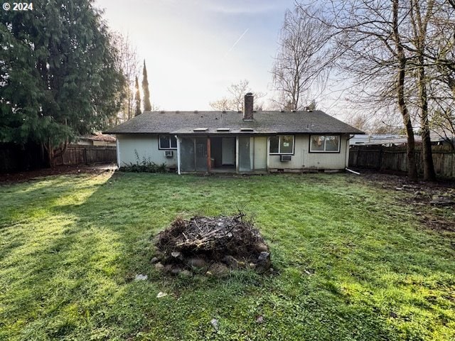 rear view of house featuring a yard