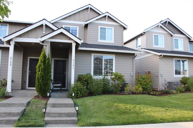 craftsman house with central AC and a front lawn