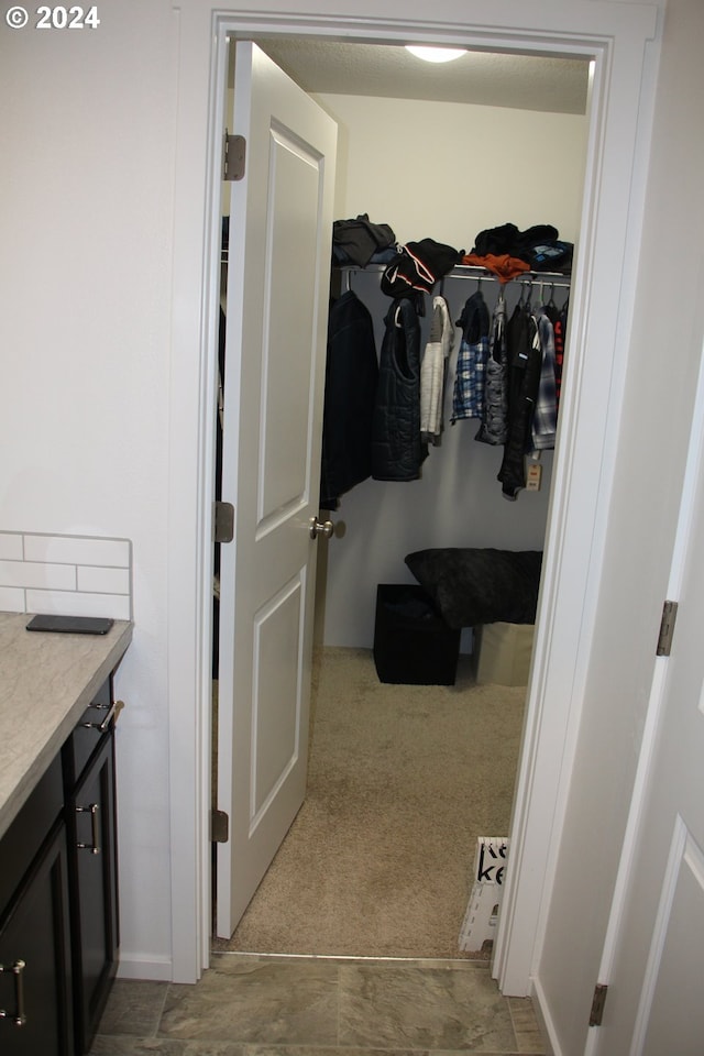 walk in closet featuring light colored carpet