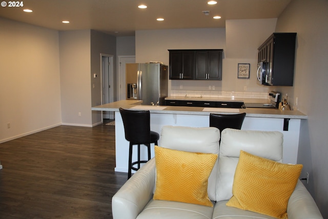 kitchen featuring stainless steel appliances, a breakfast bar area, and dark hardwood / wood-style floors