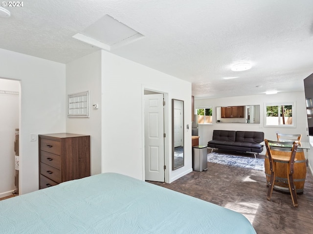 bedroom with attic access, multiple windows, and a textured ceiling