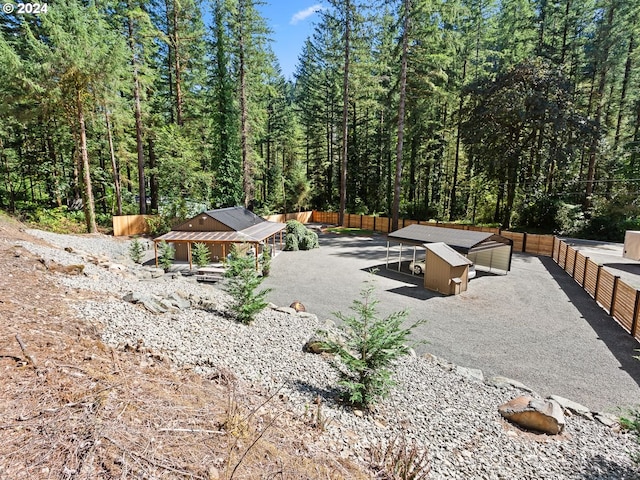 view of yard featuring a wooded view and fence