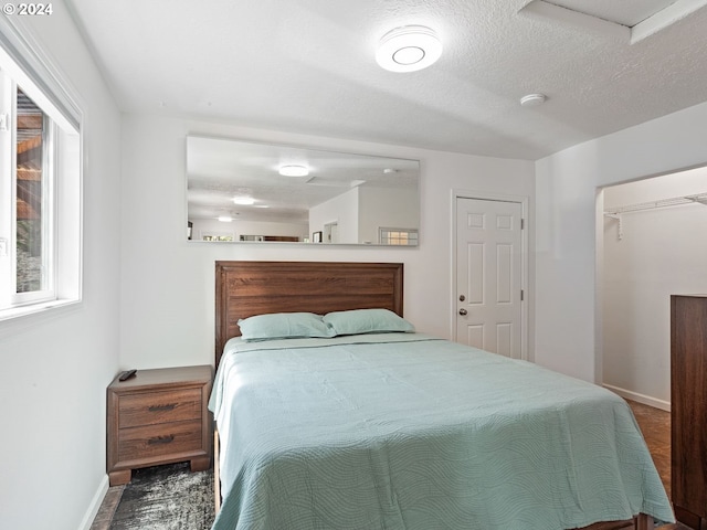 bedroom featuring a textured ceiling and baseboards