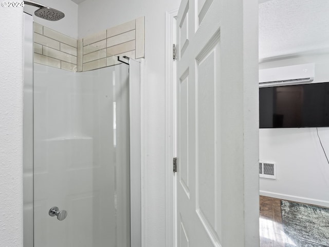 bathroom with a shower and an AC wall unit