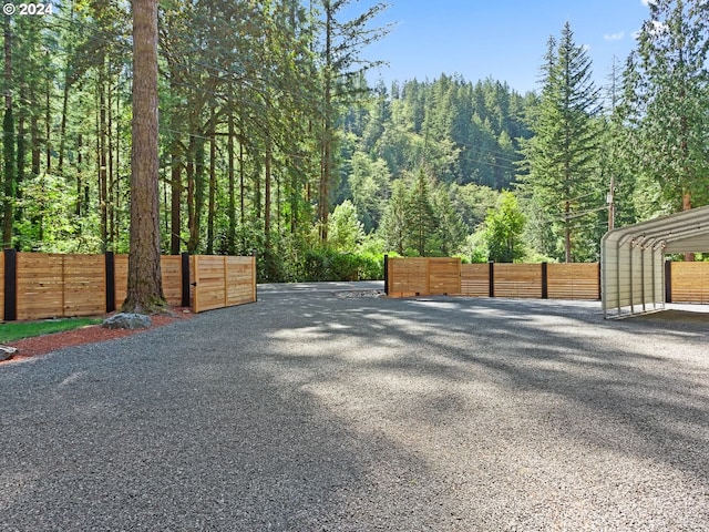 exterior space featuring a forest view and fence