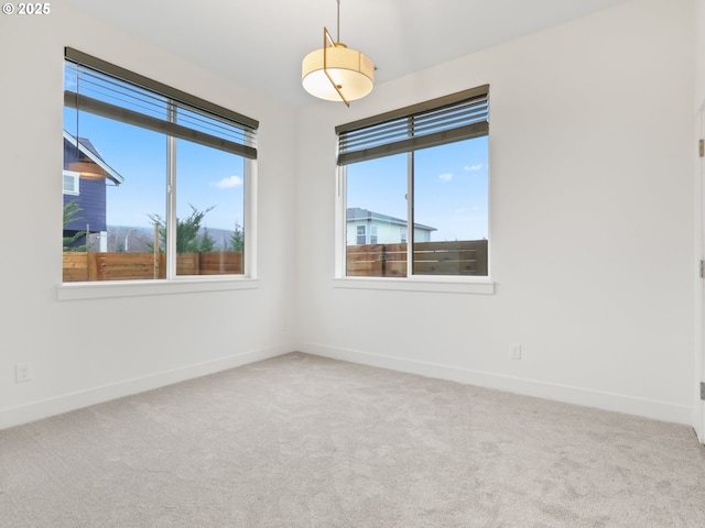 spare room featuring carpet flooring and baseboards