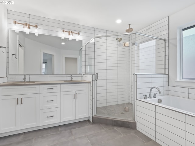 bathroom featuring a stall shower, a sink, a bath, and tile patterned floors