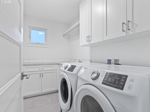 laundry room with light tile patterned floors, separate washer and dryer, and cabinet space