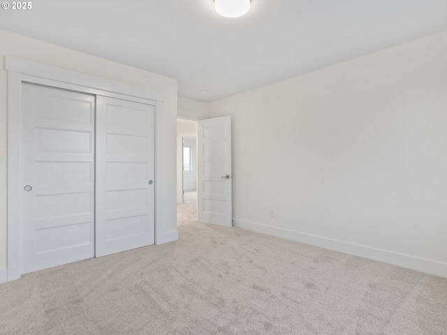 unfurnished bedroom featuring a closet, carpet flooring, and baseboards