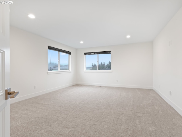 carpeted empty room featuring recessed lighting and baseboards