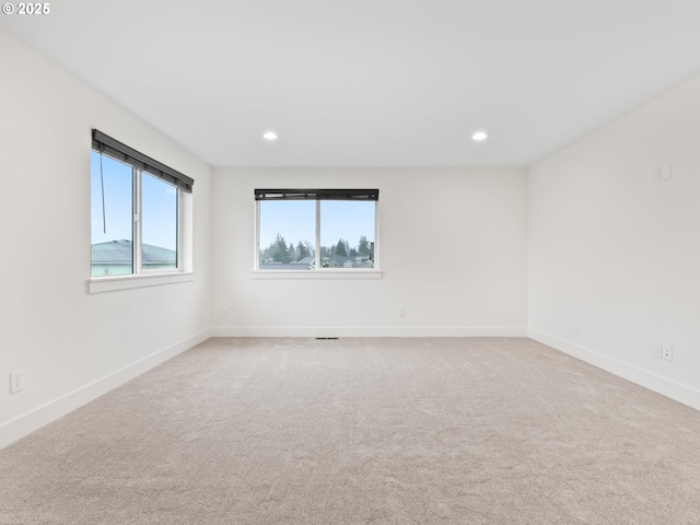 empty room with recessed lighting, light carpet, and baseboards