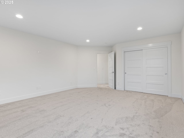 unfurnished bedroom featuring carpet, baseboards, a closet, and recessed lighting