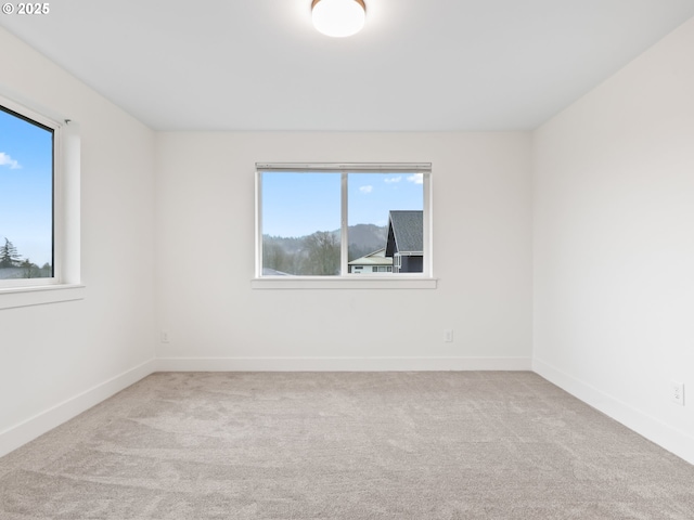 carpeted spare room with baseboards