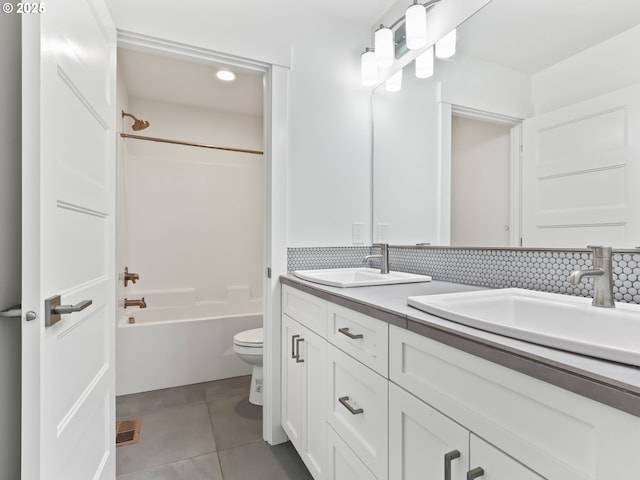 bathroom with tile patterned flooring, bathtub / shower combination, a sink, and toilet