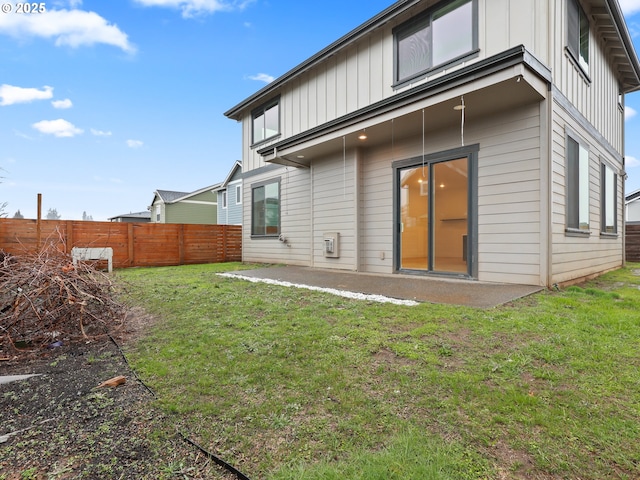 back of house featuring board and batten siding, a patio area, fence, and a lawn