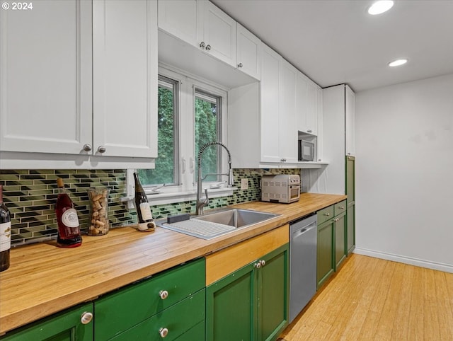 kitchen featuring white cabinets, stainless steel dishwasher, sink, and light wood-type flooring