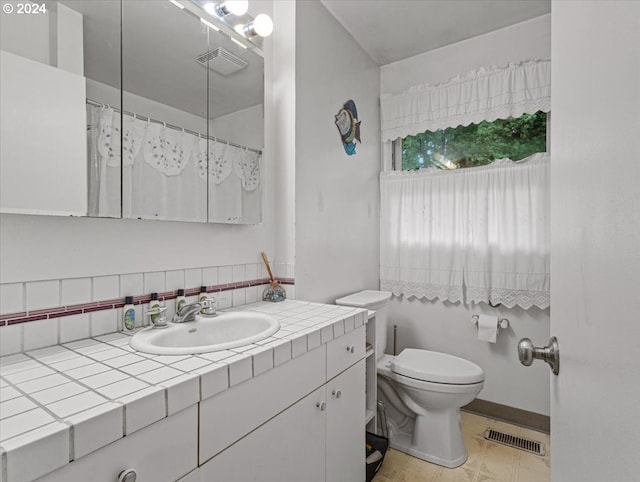 bathroom with toilet, decorative backsplash, and vanity