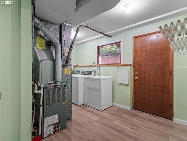 laundry area featuring washing machine and clothes dryer and light wood-type flooring