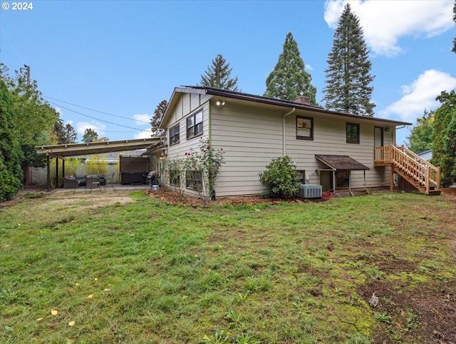 rear view of property featuring central air condition unit, a patio area, and a lawn