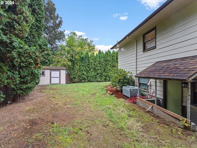 view of yard featuring a storage unit and central AC unit