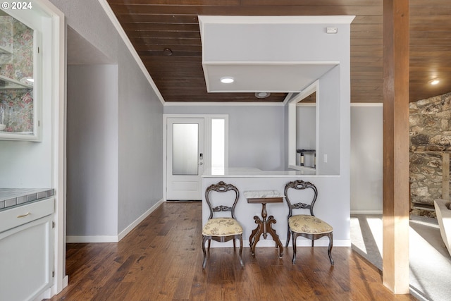 living area with dark wood-type flooring, crown molding, and wooden ceiling