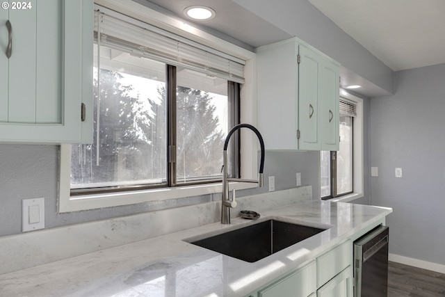 kitchen with light stone countertops, dark hardwood / wood-style floors, wine cooler, and sink