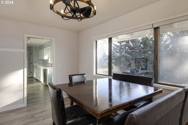 dining room with hardwood / wood-style floors, a notable chandelier, and sink