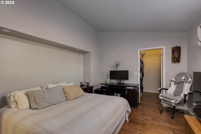 bedroom featuring a closet, a spacious closet, dark hardwood / wood-style flooring, and lofted ceiling