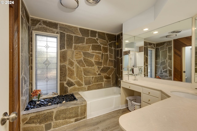 bathroom featuring a bathing tub, vanity, and wood-type flooring