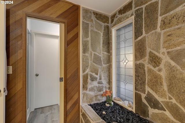 bathroom featuring hardwood / wood-style floors and wooden walls