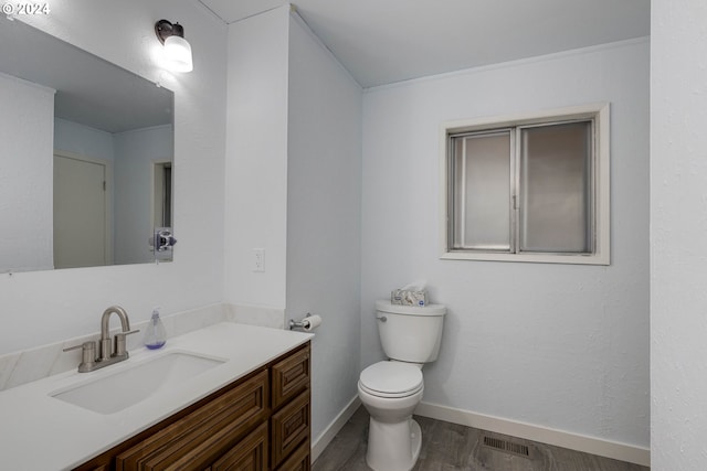 bathroom with hardwood / wood-style floors, vanity, and toilet