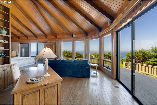 living room featuring lofted ceiling with beams, light hardwood / wood-style floors, a water view, and wooden ceiling