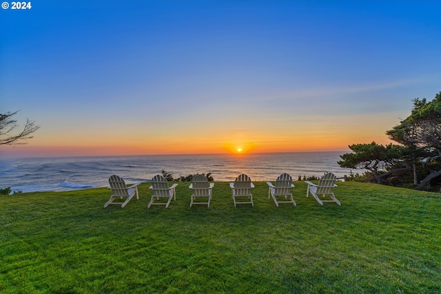 yard at dusk featuring a water view