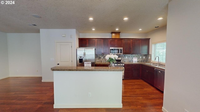 kitchen featuring dark hardwood / wood-style floors, stainless steel appliances, sink, and a kitchen island