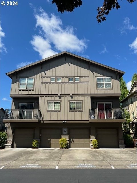 townhome / multi-family property featuring a balcony and a garage