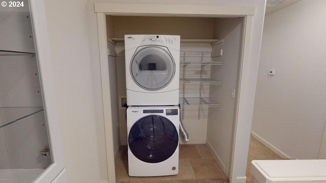 washroom with light tile patterned floors and stacked washer and dryer