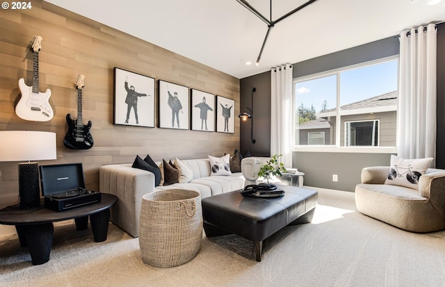 carpeted living room featuring wood walls