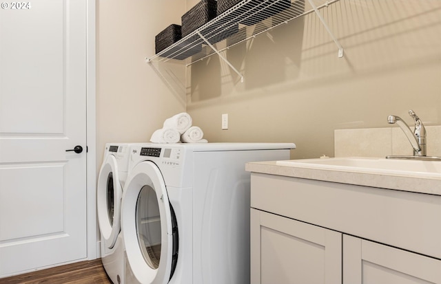 clothes washing area featuring sink, washer and dryer, and dark hardwood / wood-style floors