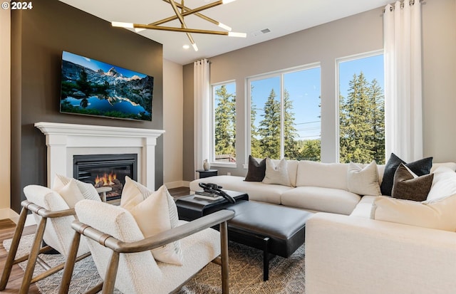 living room with hardwood / wood-style floors, a wealth of natural light, and a notable chandelier