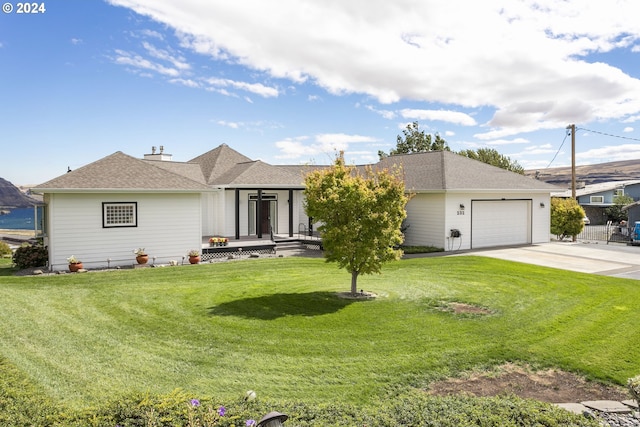 ranch-style house featuring driveway, a front yard, roof with shingles, and an attached garage