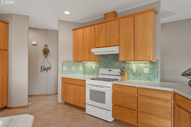 kitchen featuring white gas stove, tasteful backsplash, and light tile patterned floors