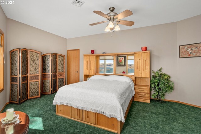 bedroom with ceiling fan and dark colored carpet