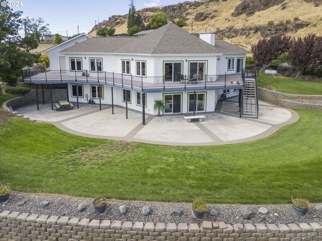 back of house featuring a patio area and a lawn