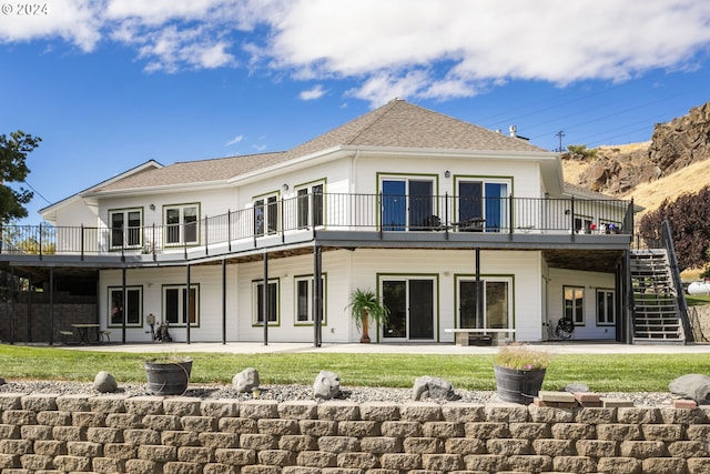 back of property with a lawn and a patio